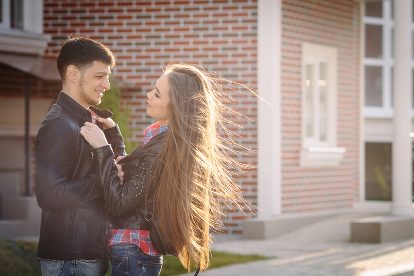 Happy moments of young couple at summer city street in evening sunlight copy space